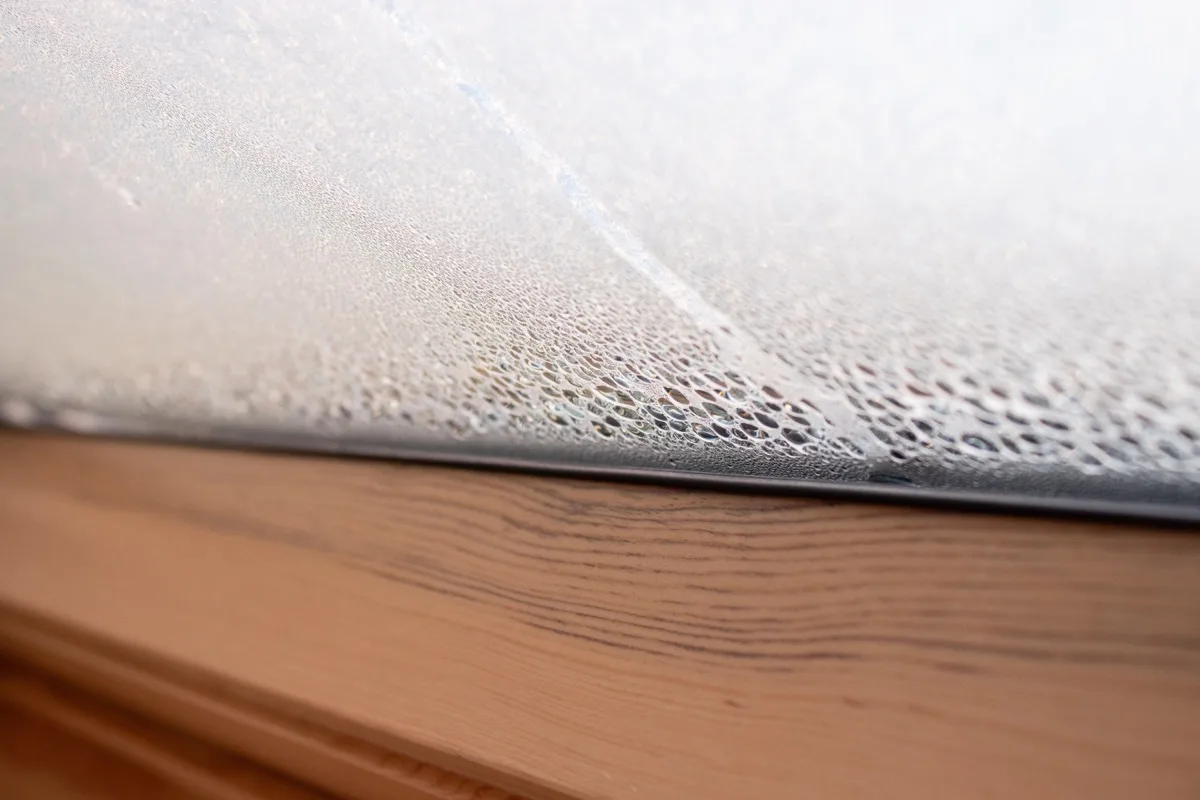 Kondenswasser am Fenster, Wassertropfen an der Innenseite der Scheibe